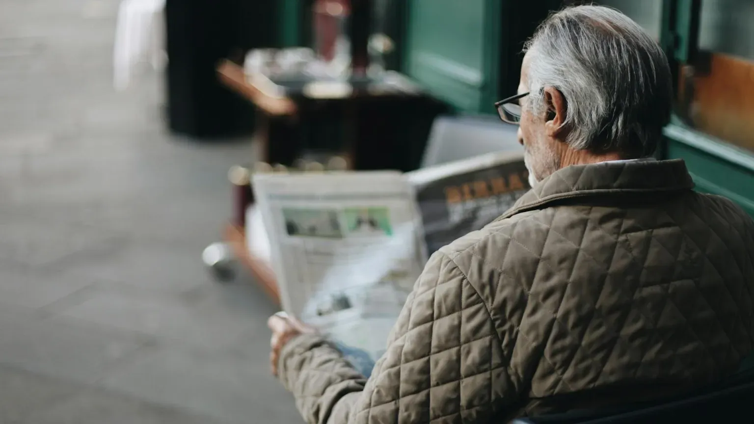 Uomo seduto che legge il giornale